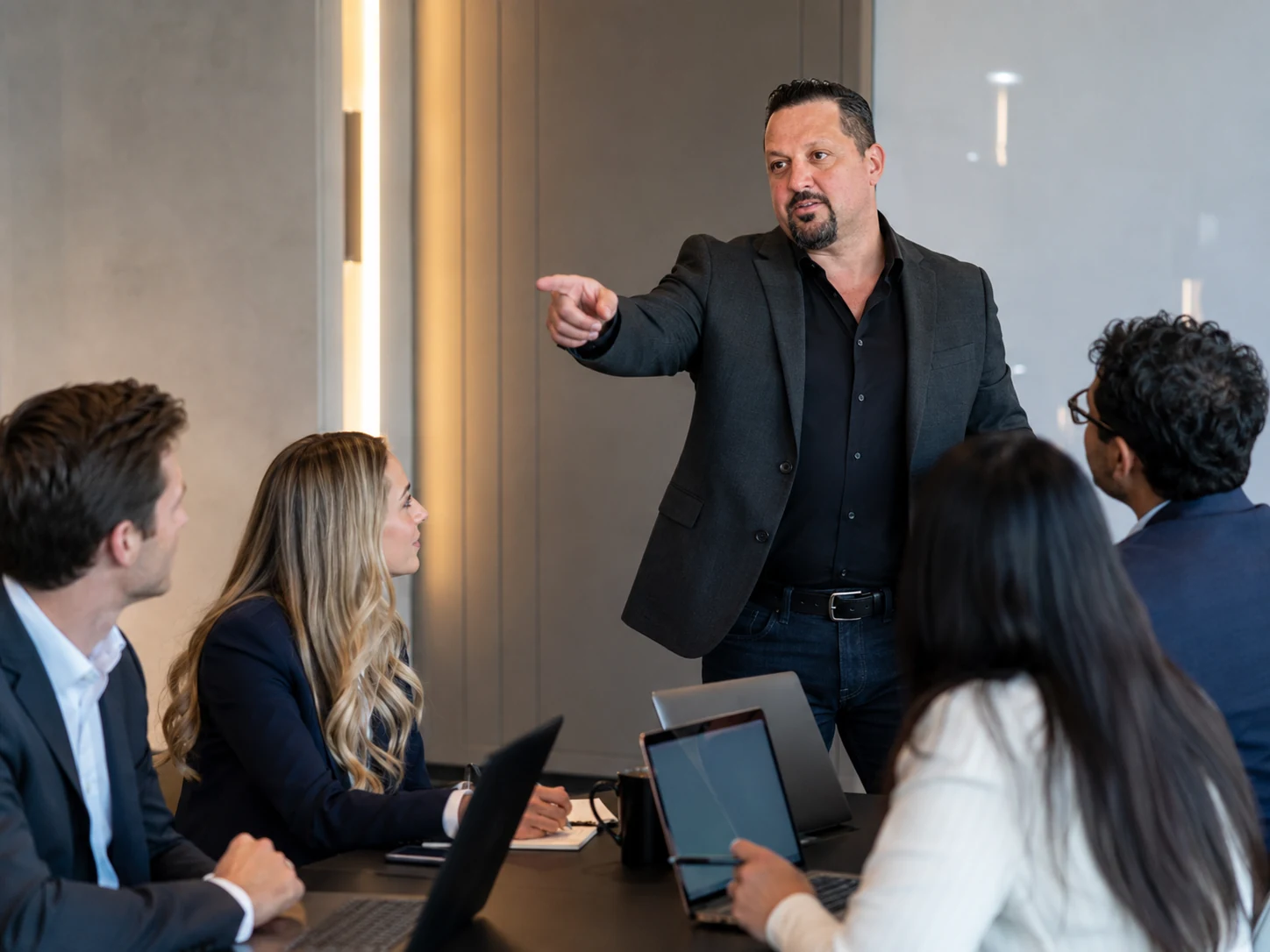 Tony Kurtulan leading team sales coaching in a modern boardroom
